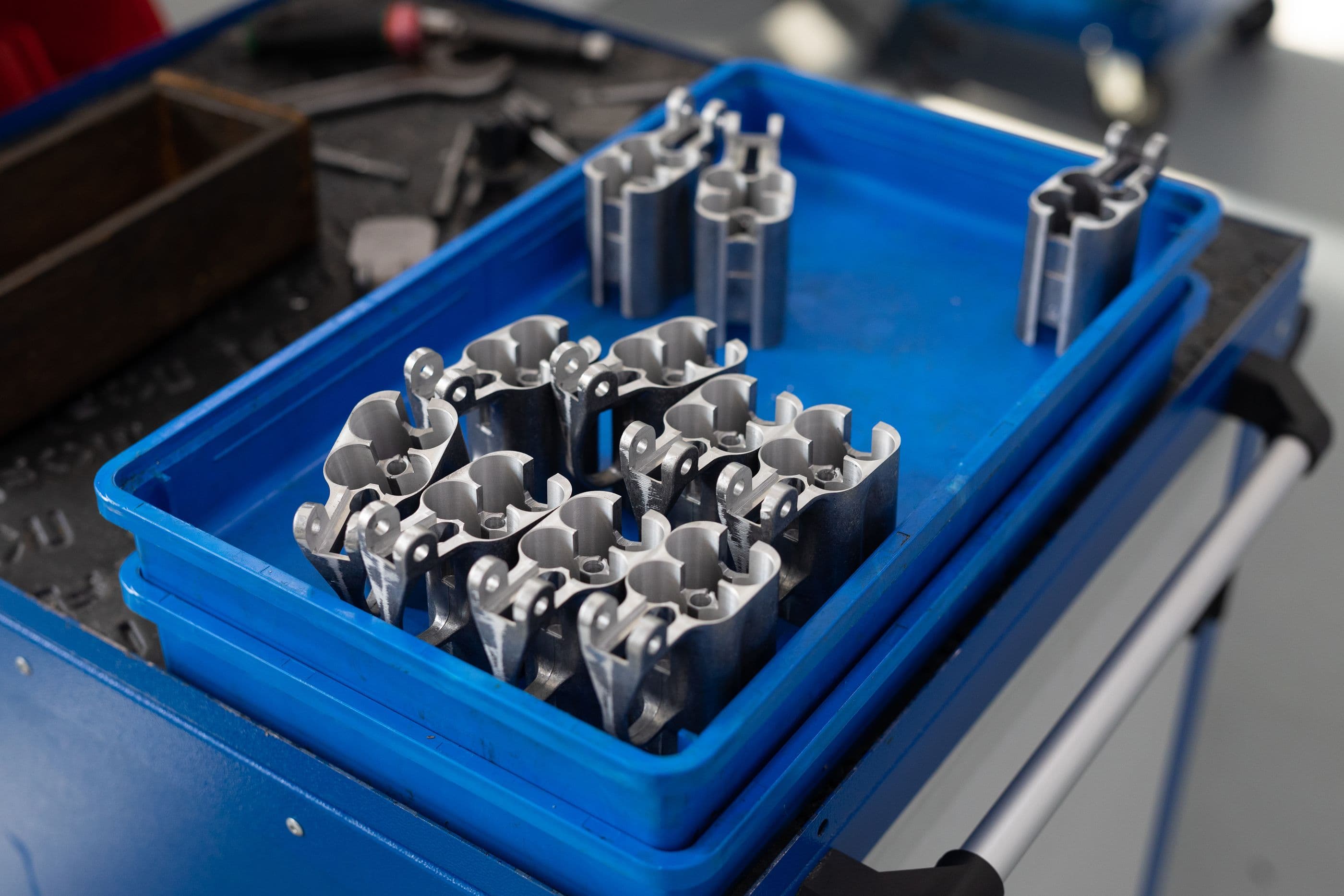 Machined aluminum parts arranged in a blue tray