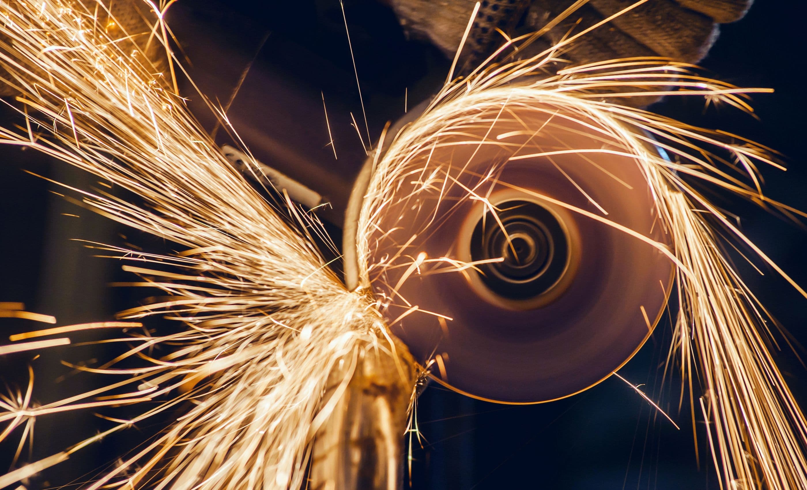 A grinding wheel throwing a bright stream of sparks
