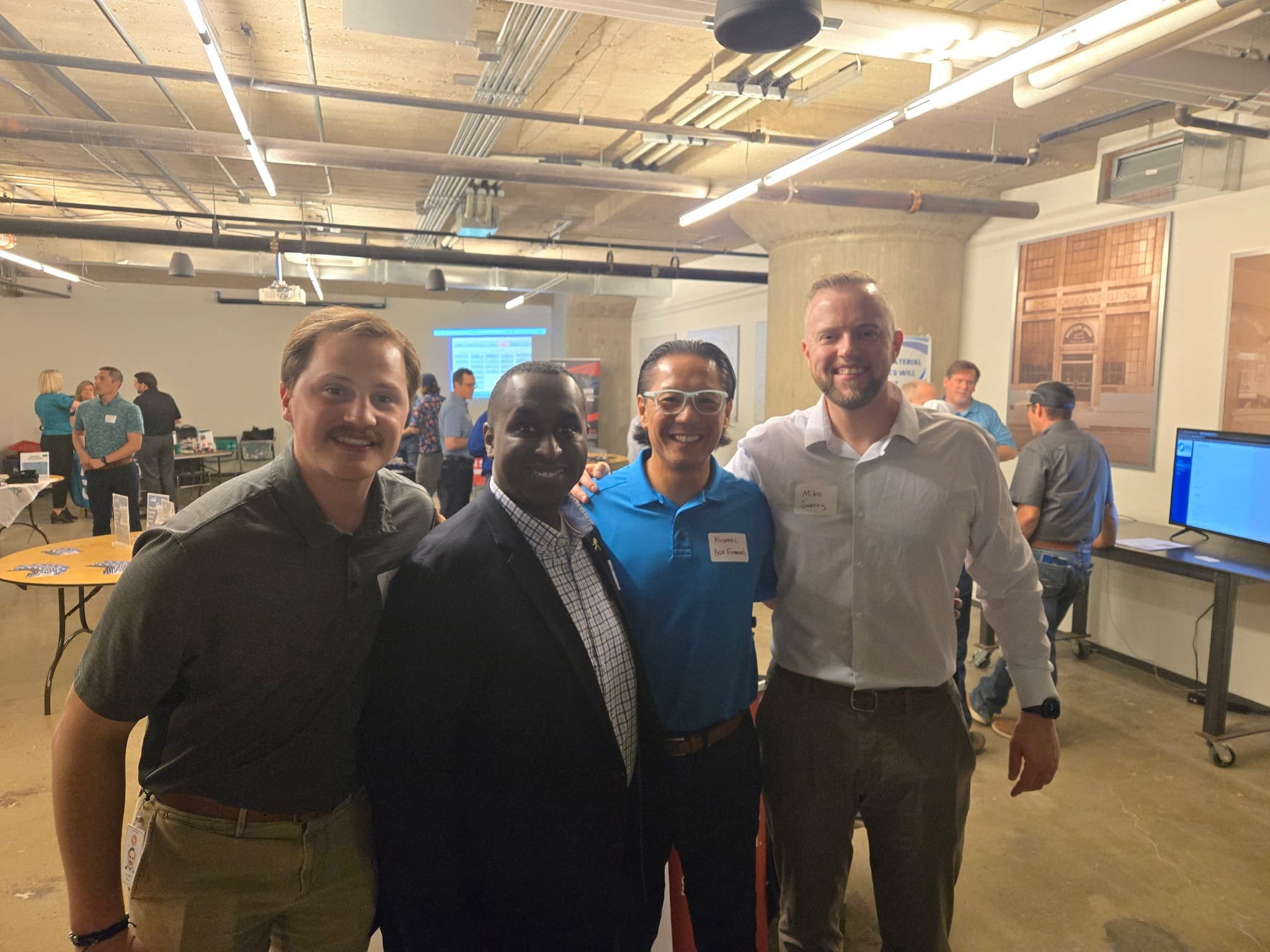 Four men standing together at an evening networking event
