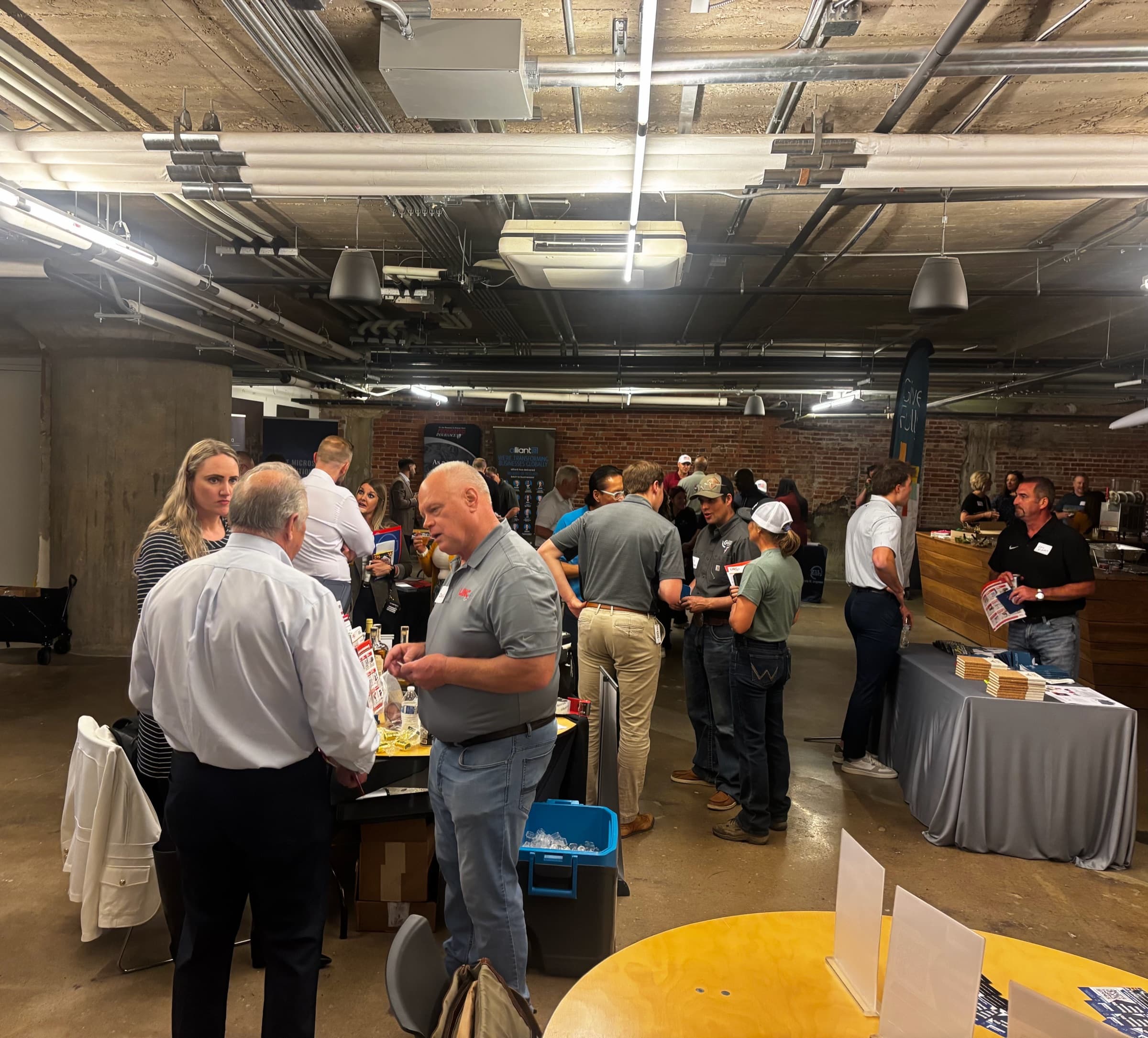 Members mingling at tables in a brick-walled event venue