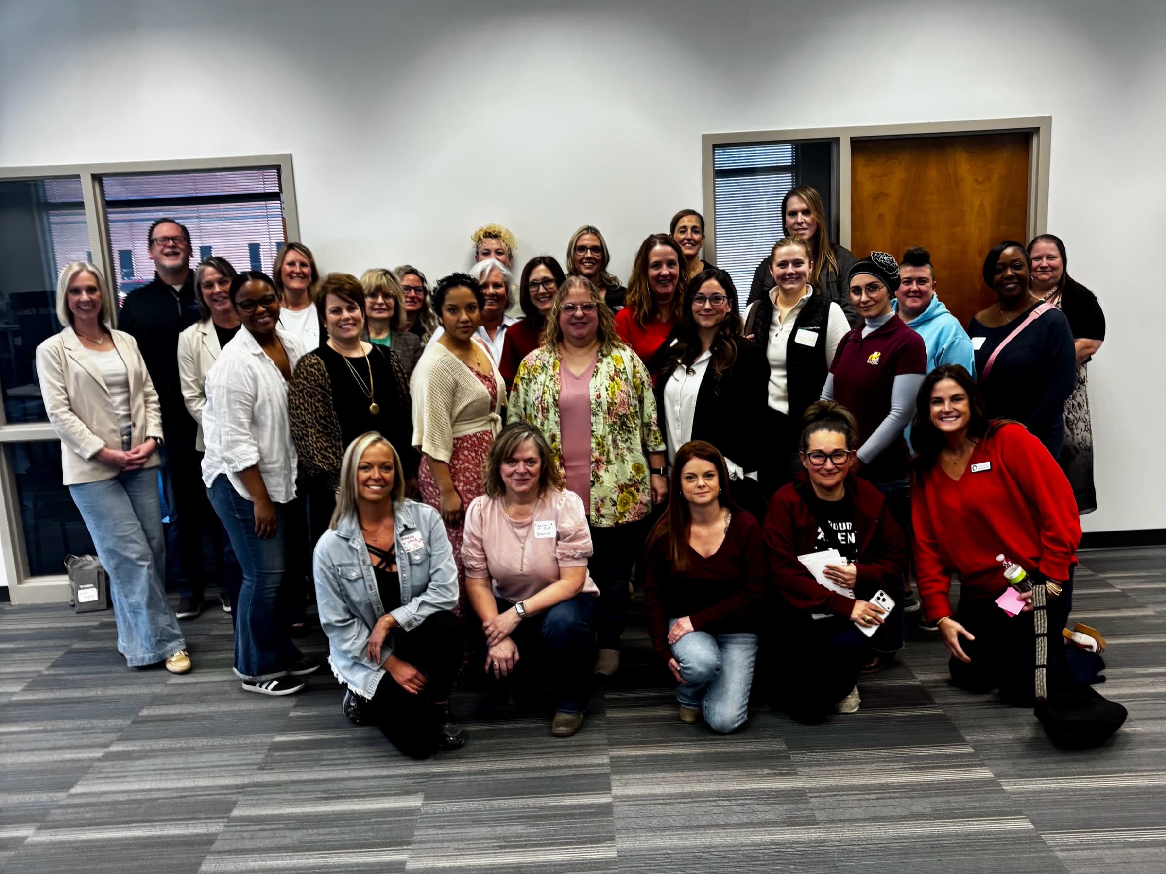 Around thirty women from She Leads gathered for a group photo in an office